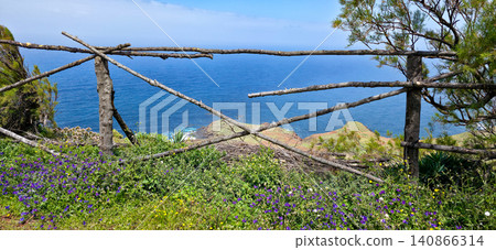 Scenic coastal landscape featuring wooden fence along a hillside with lush greenery and ocean view in a remote area. Northern viewpoint of La Palma Island Cruz de La Centinela. High quality photo Scenic coastal landscape featuring wooden fence along a hillside with lush greenery and ocean view in a remote area. Northern viewpoint of La Palma Island Cruz de La Centinela. High quality photo 140866314
