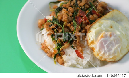 stir fried pork with holy basil on top with fried egg on cooked rice stir fried pork with holy basil on top with fried egg on cooked rice 140866417