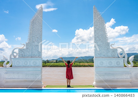 Female tourist standing at the naga gate an iconic tourist attraction in Wat Pa Yang Sob Yab temple in Chiang Saen district of Chiang Rai province of Thailand. Female tourist standing at the naga gate an iconic tourist attraction in Wat Pa Yang Sob Yab temple in Chiang Saen district of Chiang Rai province of Thailand. 140866483