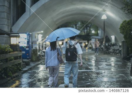 兩人共撐一把傘，背影清晰可見。 140867126