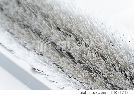 Close-up of the head of a white and gray deck brush. Close-up of the head of a white and gray deck brush. 140867131