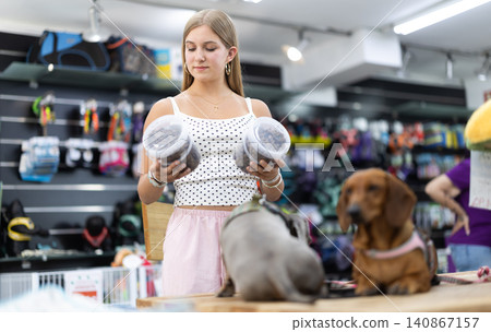 Teenage girl buys dog food in a pet store Teenage girl buys dog food in a pet store 140867157