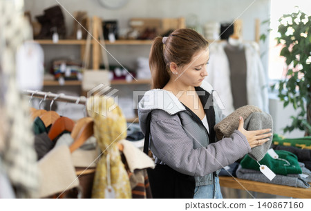 Young woman near showcase examine goods, hat. Young woman near showcase examine goods, hat. 140867160