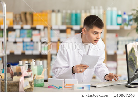 Young man pharmacist uses computer at workplace 140867246