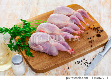 Raw gutted partridges on wooden table with seasonings and greens 140867291