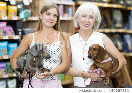 Women select suitable ammunition among the assortment of pet products. 140867313