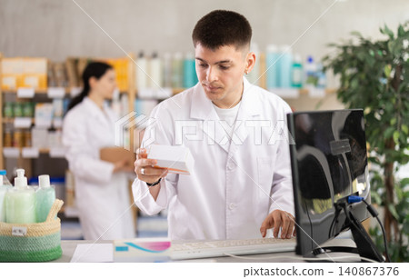 Portrait of male pharmacist working at computer in pharmacy Portrait of male pharmacist working at computer in pharmacy 140867376