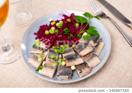On blue plate-pieces of salted herring fillet,decorated parsley and green onion,with stewed beets On blue plate-pieces of salted herring fillet,decorated parsley and green onion,with stewed beets 140867380