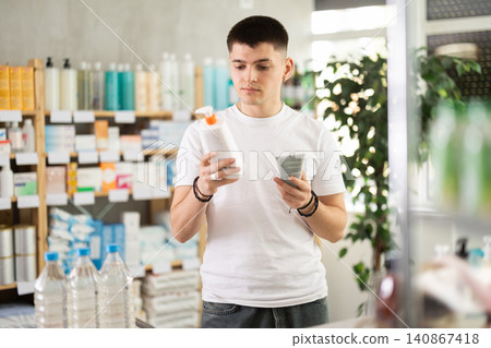 Young man choosing creams in pharmacy Young man choosing creams in pharmacy 140867418