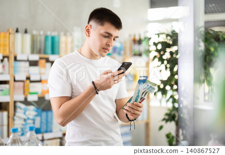 Guy scans barcode on toothbrush family set packaging Guy scans barcode on toothbrush family set packaging 140867527