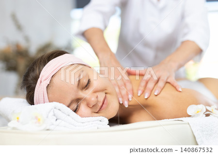 Female masseur works out shoulder and back problem area for female athlete client. Close-up Female masseur works out shoulder and back problem area for female athlete client. Close-up 140867532