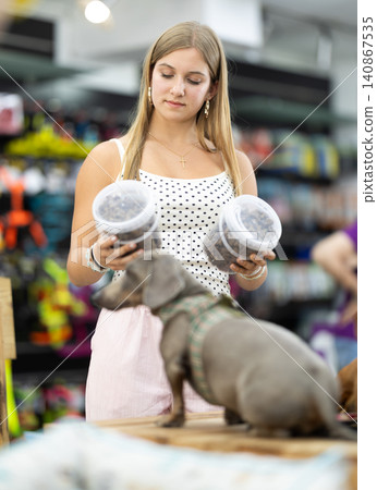 Teenage girl buys dog food in a pet store Teenage girl buys dog food in a pet store 140867535