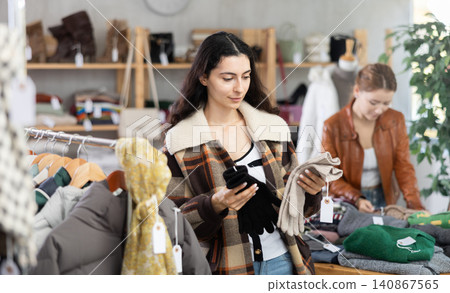 Armenian woman near showcase examine goods, buying gloves. Armenian woman near showcase examine goods, buying gloves. 140867565