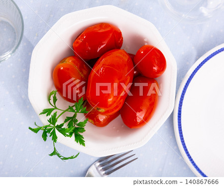 Juicy marinated tomatoes served on plate decorated with parsle. Homemade canning. Pickled vegetables Juicy marinated tomatoes served on plate decorated with parsle. Homemade canning. Pickled vegetables 140867666