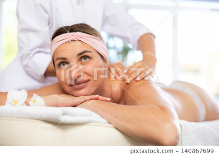 Adult woman gets back and shoulder massage Adult woman gets back and shoulder massage 140867699