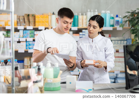 Man choosing prescription medications with help of pharmacist Man choosing prescription medications with help of pharmacist 140867706