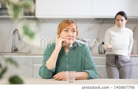 Sad mature woman arguing with her distressed daughter in kitchen 140867790