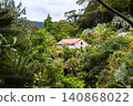 A scene of a house with red tiles in the middle of the forest. 140868022