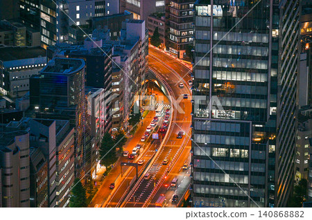 夜幕降臨,高速公路的燈光蜿蜒穿過市中心。 夜幕降臨,高速公路的燈光蜿蜒穿過市中心。 140868882