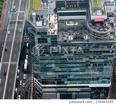 High-rise building with a highway and rooftop terrace (daytime) 140868889