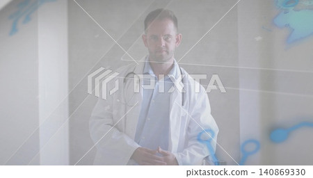 Standing male physician wearing lab coat and stethoscope in clinic portrait with molecular overlay 140869330
