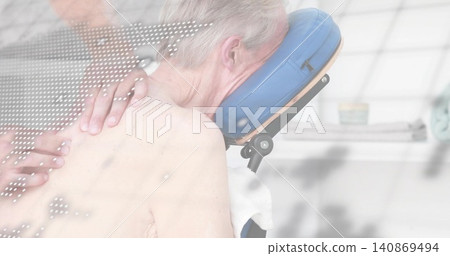 Therapist hands pressing shirtless man resting prone on chair in spa with blue cradle and towel 140869494