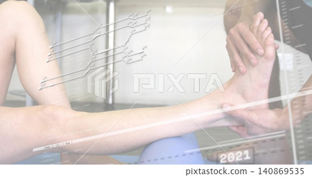 Holding dark-sleeve therapist hands supporting patient's bare leg in clinic with blue roller, 2021 Holding dark-sleeve therapist hands supporting patient's bare leg in clinic with blue roller, 2021 140869535