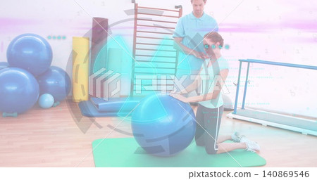 Kneeling midadult woman in sportswear leaning on large blue exercise ball in rehab studio, with HUD Kneeling midadult woman in sportswear leaning on large blue exercise ball in rehab studio, with HUD 140869546