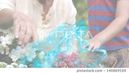 Working senior and boy in flower bed, cream top, striped tee, turquoise swirl, ringed hand, pruner 140869589