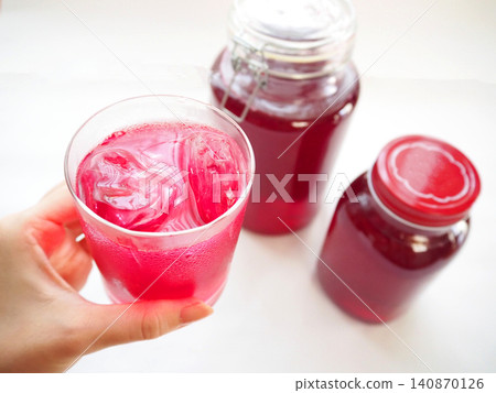 Red perilla juice in a glass and red perilla syrup in a bottle Red perilla juice in a glass and red perilla syrup in a bottle 140870126