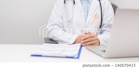 doctor using laptop and report notes on notebook. peach ribbon concept of September Uterine Cancer Awareness month, Endometrial, Gynecologic, Uterus and Ovaries, Endometriosis, June Vaginal cancer doctor using laptop and report notes on notebook. peach ribbon concept of September Uterine Cancer Awareness month, Endometrial, Gynecologic, Uterus and Ovaries, Endometriosis, June Vaginal cancer 140870415