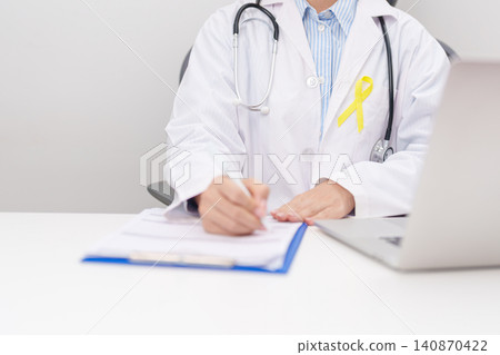 doctor using laptop and report notes on notebook for Gold Yellow Ribbon for concept of September Childhood Awareness month, July Sarcoma, bone and bladder, support survivor. World Cancer day doctor using laptop and report notes on notebook for Gold Yellow Ribbon for concept of September Childhood Awareness month, July Sarcoma, bone and bladder, support survivor. World Cancer day 140870422