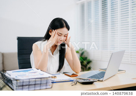 Focused businesswoman sorting documents at a cluttered desk with reports, coffee cups, and files. Perfect for accounting, finance, tax season, and deadline stress concepts. Focused businesswoman sorting documents at a cluttered desk with reports, coffee cups, and files. Perfect for accounting, finance, tax season, and deadline stress concepts. 140870638