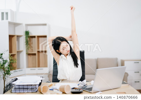 Young Asian woman suffering neck pain while working from home with laptop. Concept of stress, fatigue, burnout, workload and remote work challenges. Young Asian woman suffering neck pain while working from home with laptop. Concept of stress, fatigue, burnout, workload and remote work challenges. 140870666