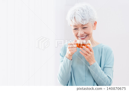 Senior woman drinking a hot drink Senior woman drinking a hot drink 140870675
