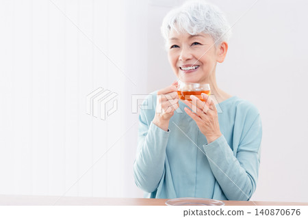 Senior woman drinking a hot drink Senior woman drinking a hot drink 140870676