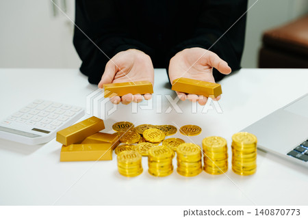 Gold coins and bars stacked beside laptop with market chart. Investment, finance, trading, profit growth, wealth strategy and business analysis concept. Gold coins and bars stacked beside laptop with market chart. Investment, finance, trading, profit growth, wealth strategy and business analysis concept. 140870773