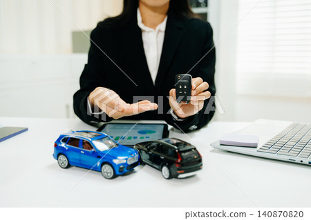 Businesswoman holding car remote key with auto insurance, vehicle sales and financing concept, dealership service, investment strategy Businesswoman holding car remote key with auto insurance, vehicle sales and financing concept, dealership service, investment strategy 140870820