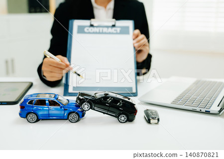 Car accident models with insurance contract and pen. Auto claim, coverage, liability, compensation and settlement process in modern business office. Car accident models with insurance contract and pen. Auto claim, coverage, liability, compensation and settlement process in modern business office. 140870821