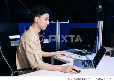 Trader analyzing stock market charts and financial data in a modern workspace, ideal for investment, fintech, trading 140871086