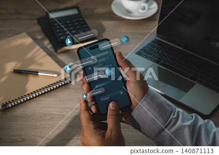 Hand uses smartphone with AI chatbot interface, floating message bubbles, prompt icons and laptop workspace, showing digital assistant communication and automation for business workflow. Hand uses smartphone with AI chatbot interface, floating message bubbles, prompt icons and laptop workspace, showing digital assistant communication and automation for business workflow. 140871113