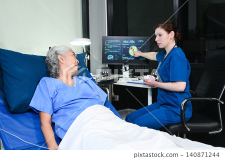 A professional nurse points to brain scan results on a monitor while consulting an elderly patient, representing medical diagnostics, neurology, A professional nurse points to brain scan results on a monitor while consulting an elderly patient, representing medical diagnostics, neurology, 140871244