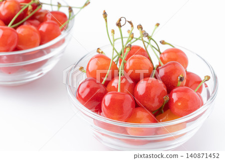 Cherries (Sato Nishiki variety) in a glass container against a white background. Cherries (Sato Nishiki variety) in a glass container against a white background. 140871452