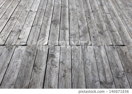 Weathered gray wooden planks form a rustic outdoor deck Weathered gray wooden planks form a rustic outdoor deck 140871836