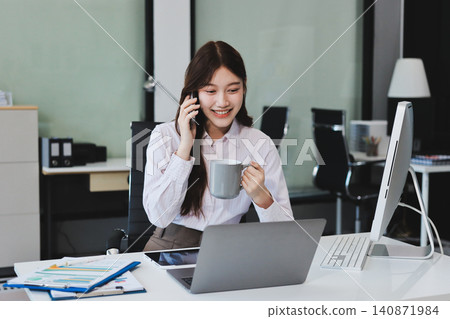 Young businesswoman professional employee using pc doing online banking analysing at workplace. Asian middle-aged business woman working on laptop computer in office, taking notes. Banner, copy space Young businesswoman professional employee using pc doing online banking analysing at workplace. Asian middle-aged business woman working on laptop computer in office, taking notes. Banner, copy space 140871984