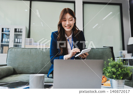Asian businesswoman sitting at work using laptop talking and consulting in office 140872017