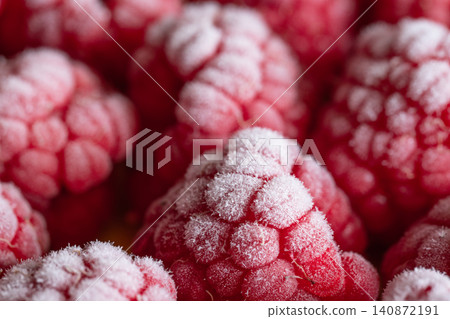 Closeup view of frost-kissed raspberries with icy sugar crystals, rich red berries resting in a natural cluster and highlighting textured surfaces Closeup view of frost-kissed raspberries with icy sugar crystals, rich red berries resting in a natural cluster and highlighting textured surfaces 140872191