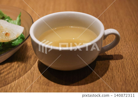 Clear broth soup in ceramic cup served with meal Clear broth soup in ceramic cup served with meal 140872311