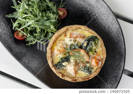 salmon and broccoli quiche with salad healthy meal on white cafe table 140872505
