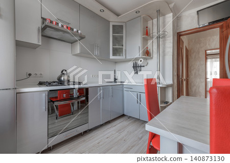 Contemporary Apartment Kitchen Interior with Grey Cabinets and Red Chairs Contemporary Apartment Kitchen Interior with Grey Cabinets and Red Chairs 140873130